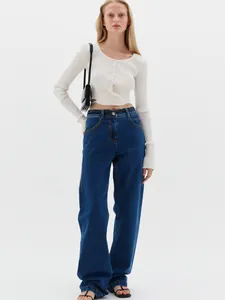 Detail of high-waist wide-leg jeans featuring orange contrast stitching and black leather belt