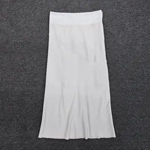 Detail of light beige midi skirt showing elastic waistband and drawstring on gray rug