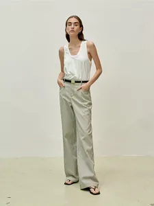 Minimalist white sleeveless tank top paired with striped wide-leg trousers and thin belt