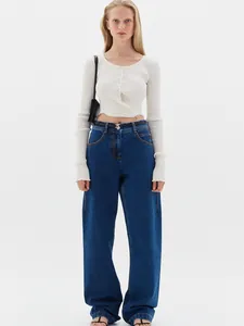 Close-up of white ribbed knit cardigan with front ties and matching high-waist denim pants