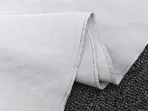 Macro detail of the gray textile fabric showing weave texture and professional overlock stitching
