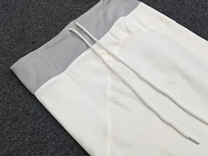 Detail of high-waisted elastic band with drawstring and metal tips on midi skirt