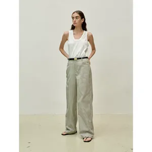 Minimalist white sleeveless top paired with high-waist striped trousers and black belt