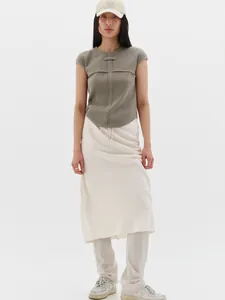 Detail of olive waffle knit top and cream satin skirt ensemble with minimalist styling