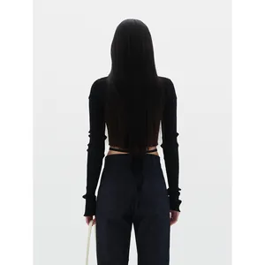Back view of a chic black ribbed knit cardigan paired with indigo denim jeans