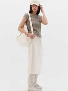 Detail of Korean style drawstring midi skirt paired with waffle knit top and casual tote bag