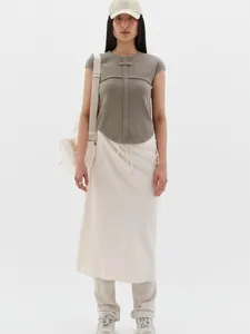 Detail of grey-green waffle knit vest and cream midi skirt with drawstring waist