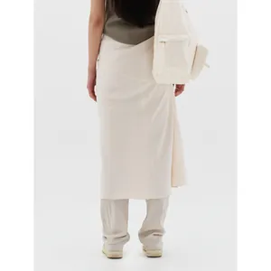 Elegant ivory drawstring midi skirt and layered trousers with minimalist canvas backpack