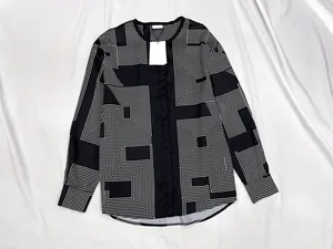 Detail of black geometric print shirt featuring smooth fabric and hidden button placket