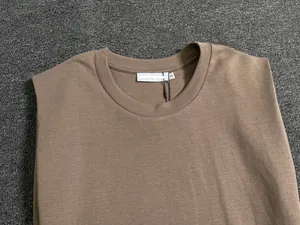 Detail of crew neck stitching and premium cotton texture on a dark brown tank top