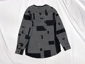 Detailed flat lay of geometric maze print shirt with a smooth satin texture and curved hem