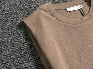 Detail of a brown sleeveless top showing neckline stitching and cotton fabric texture