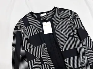 Detail view of smooth silk-like fabric with black and white geometric linear patterns