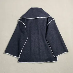 Detailed view of white scalloped stitching on a dark grey wool scarf jacket