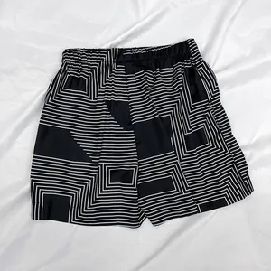 Detailed view of geometric print shorts with elastic waistband on white silk background