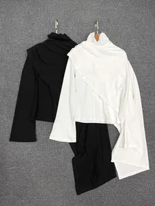 Close-up of asymmetrical draped layers and soft knit texture on two-piece top set