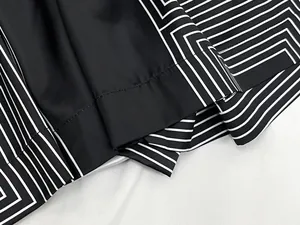 Detailed view of geometric black and white patterned fabric with fine stitching quality