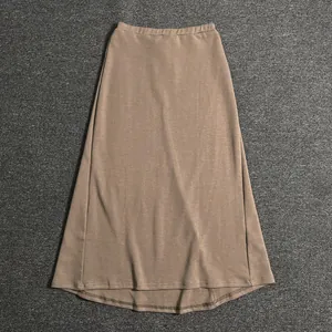 Detail of a brown A-line maxi skirt featuring a high elastic waist and knitted texture
