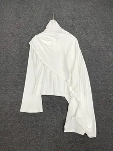 Detail of white high-neck knit top with asymmetric draping and elegant layered pleats