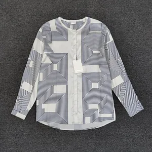 Detail of loose-fit long sleeve shirt featuring navy geometric labyrinth print on off-white satin
