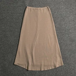 Flat lay of a brown A-line midi skirt with elastic waist and textured diagonal seam