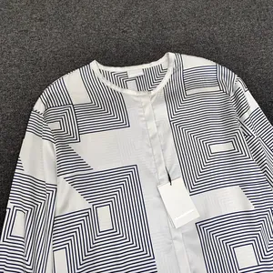 Detail of round neckline and geometric pattern on long-sleeved satin texture blouse