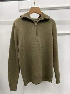 Detail view of olive green knit hoodie with half-zipper collar and ribbed texture fabric