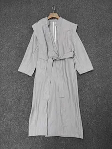 Détail de la texture du trench-coat gris clair et de la ceinture amovible à la taille