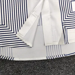 Close-up of geometric pattern hem with fine stitching and side slit on the shirt