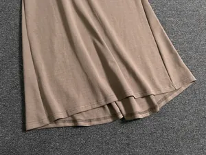 Detailed close-up of double-needle stitching on the hem of a brown knit skirt