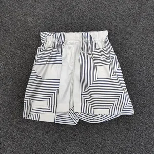 Detail of geometric pattern satin shorts with elastic waistband on grey background
