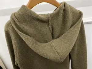 Detail view of olive green knitted hoodie featuring premium stitching and flat knit texture