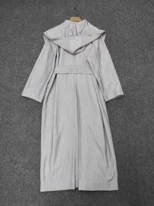 Détail du dos d'un manteau à capuche gris clair avec ceinture et coupe minimaliste épurée