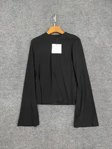 Detailed macro view of black cotton knitted top featuring flared sleeves and round neckline