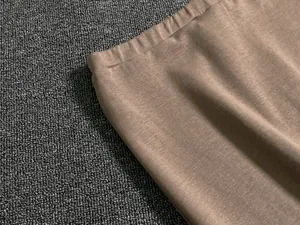 Macro detail of brown knitted skirt waist with elastic band and vertical texture