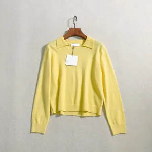 Detailed view of yellow polo neck knit sweater showing collar texture and brand tag