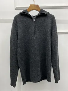 Detailed texture of dark grey half-zip hooded sweater with fine knit and silver metal zipper