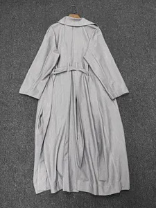 Vue détaillée du dos d'un trench-coat long gris clair avec ceinture et fente arrière