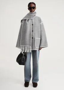 Detail of grey wool coat showing white blanket stitching and fringe hem decoration