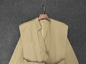 Detailed view of wide shawl lapel and refined inner piping on khaki trench coat