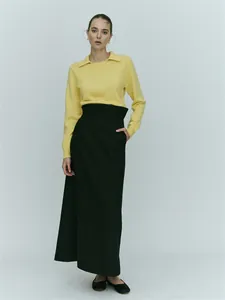 Minimalist light yellow long-sleeve knit polo shirt paired with a high-waist black maxi skirt