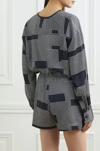 Detail view of navy satin loungewear set with white geometric maze print