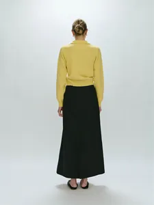 Back view of a yellow polo neck knit sweater paired with a long black straight skirt