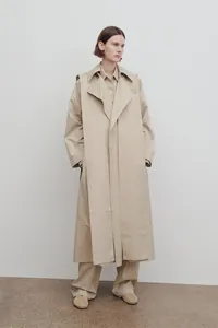 Detailed view of khaki trench coat with large layered collar and oversized silhouette