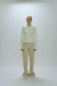 Elegant two-piece set with a white long-sleeve top and high-waisted beige trousers