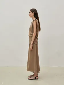 Detail view of khaki knit two-piece set featuring padded shoulder top and long pencil skirt