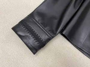 Close-up of black leather shirt showing premium texture and intricate hand-stitched seams