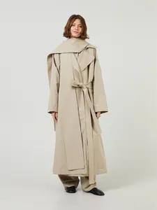 Detail view of khaki long trench coat with detachable hood and layered shoulder design