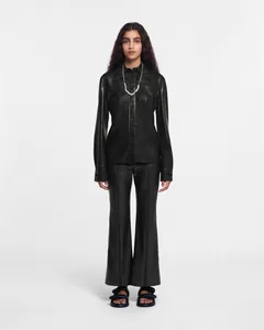 Full-body shot of a black faux leather long-sleeve shirt and matching flared trousers set