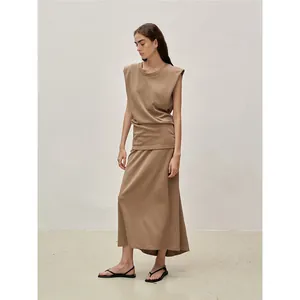 Minimalist two-piece women's set featuring a padded shoulder top and long skirt in tan